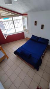 乌巴图巴Maré Alta Hostel的一间位于客房内的蓝色床卧室