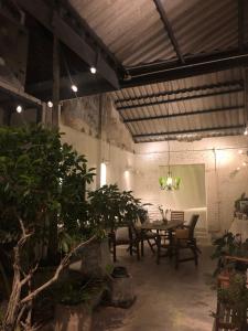 普吉镇97 Yaowarat - Phuket Old Town的用餐室配有桌椅和植物