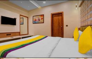 伯杰默里Hotel Abhilasha inn的一间卧室配有一张大床和电视