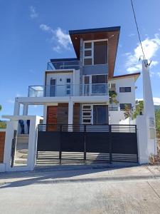 马里韦莱斯Casa Amores: Camaya Coast的一座带黑色围栏的大型白色房屋