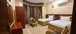 阿尔布亚米AL AMAN HOTEL的酒店客房,配有两张床和椅子