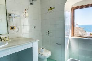 焦维纳佐圣马汀酒店的一间带卫生间、水槽和窗户的浴室