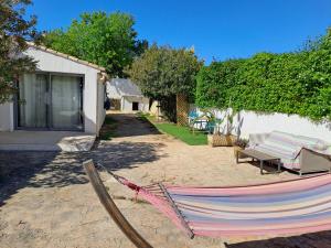 滨海圣西尔Chambre indépendante climatisée, terrasse 100M2 et salle d'eau的房屋旁的院子内的吊床