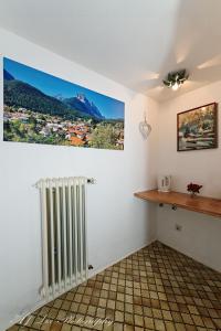 米滕瓦尔德卡纳膳食公寓酒店的一间房间,配有暖气和墙上的照片
