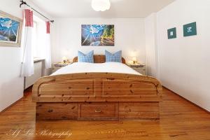米滕瓦尔德卡纳膳食公寓酒店的一间卧室配有一张带蓝色枕头的大型木制床。