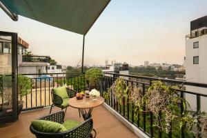 河内Hanoi Tunger Premium Hotel & Travel的设有一个配有桌椅并享有美景的阳台。