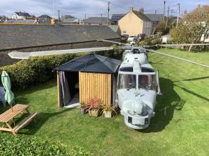 赫尔斯顿Haelarcher Helicopter Glamping的直升机停在草地上,有帐篷