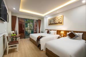 河内Hanoi Tunger Premium Hotel & Travel的酒店客房设有两张床和窗户。