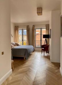 凡尔赛Grande maison hyper centre Versailles的一间卧室配有一张床、一把椅子和窗户。