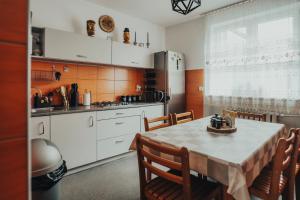 杜什尼基-兹德鲁伊Willa Baca的一间带桌椅的厨房和一间带白色橱柜的厨房