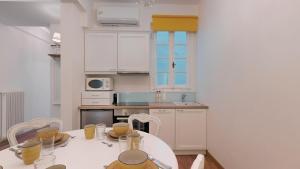 雅典The Koukaki Residence的厨房配有白色的桌椅和桌子,厨房