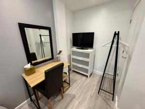 贝肯翰姆Cosy Budget Room的客房设有带镜子的书桌和电视。