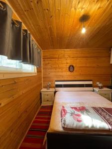 佩尔梅特Origjina Farm的木制客房内的一间卧室,配有一张床