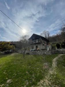 佩尔梅特Origjina Farm的一座带草地庭院的山丘上的石头房子