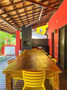 马塔迪圣若昂Casa do Lord - Natú的一张大木桌,房间配有黄色椅子