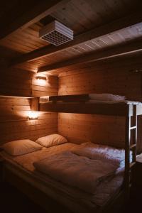 盖郎厄尔峡湾文杰露营地的木墙客房的一张床位,配有两张双层床
