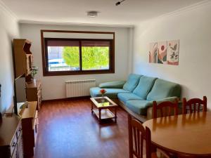 萨米艾拉Apartamento con jardín y piscina temporada verano privados的客厅配有蓝色的沙发和桌子