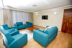 MeruWHITE LOTUS EXECUTIVE APARTMENT的客厅配有2张蓝色的沙发和1张桌子