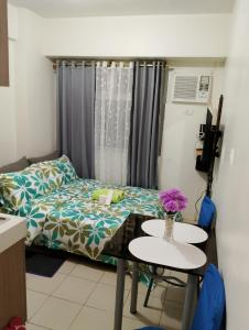 马尼拉Zafreen Staycation/CONDOTEL的一间房间,里面设有一张床和一张鲜花桌