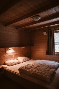 盖郎厄尔峡湾文杰露营地的木制客房内的一间卧室,配有一张床