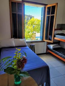 里约热内卢Rio World Connection Hostel的一间卧室,配有一张蓝色的床,桌子上放着植物