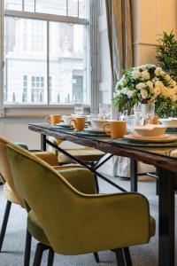 伦敦Stylish 3 Bedroom Luxury in Harley Street - 3HS的餐桌、椅子和花瓶