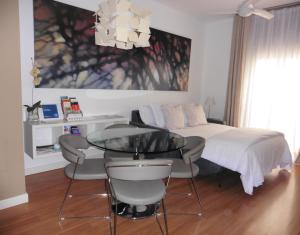 马拉加Apartamento Barrio Picasso的卧室配有一张床和一张桌子及椅子
