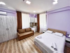 安布罗劳里Khidikari Hotel的卧室配有一张白色大床和一把椅子