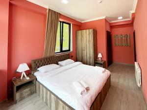 安布罗劳里Khidikari Hotel的一间卧室设有一张带红色墙壁的大床