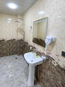安布罗劳里Khidikari Hotel的一间带水槽、淋浴和镜子的浴室