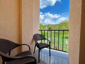 安布罗劳里Khidikari Hotel的两把椅子坐在阳台,可望见窗外