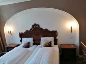 昆塔尔Historisches Hotel Bären的卧室设有两张床铺和拱门