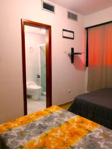 Boca de AroaTucacas, Sotavento的一间卧室配有一张床,浴室设有卫生间