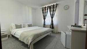泽尔内什蒂Casa Nicoladis的白色的卧室设有床和窗户