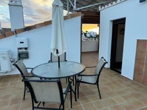 米哈斯Casa Topacio Luxury Villa, 3 bedrooms sleeps 8的阳台配有桌椅和遮阳伞