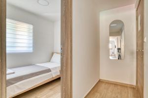 里桑Apartments Pavic的一间小卧室,配有一张床和镜子