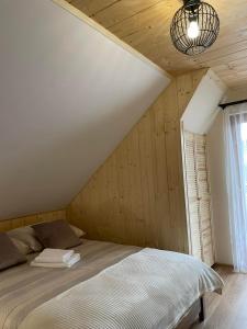 比利但耶克Apartament 4 os u Króla的卧室配有一张床铺,位于带木墙的房间内