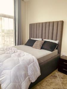 达累斯萨拉姆Luxurious haven retreat的卧室设有一张大床,卧室设有大窗户