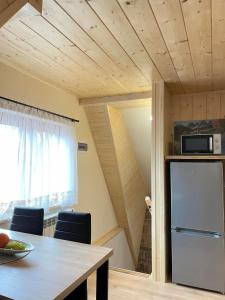 比利但耶克Apartament 4 os u Króla的客房内的厨房配有桌子和冰箱