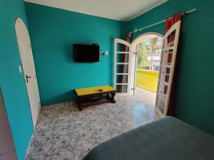 瓜鲁雅Pousada Sereia Tropical的一间设有床铺和墙上电视的房间