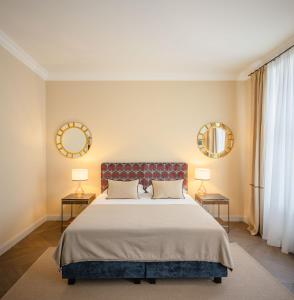 维也纳Roosevelt Stadthaus的一间卧室配有一张大床,配有两盏灯和镜子