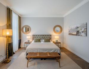维也纳Roosevelt Stadthaus的一间卧室配有一张大床,设有两张桌子和两面镜子