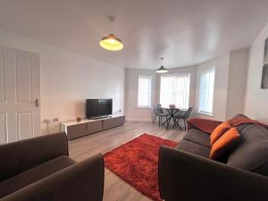 Ocker HillShazeal Apartment Tipton的带沙发和平面电视的客厅