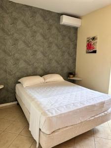 Sabana Westpunt蓝佐索布里诺酒店的卧室内的一张床位,卧室设有墙壁