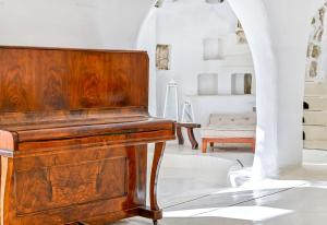 伊斯基亚拉韦诺公寓式酒店的一把木钢琴,放在带椅子的房间