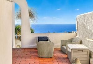 伊斯基亚Villa Ravino Secret Retreat的一个带桌椅的海景庭院