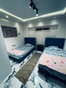 艾因苏赫纳بورتو السخنة的客房内设有两张床,铺有大理石地板。