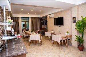 巴库Sebail Inn Hotel的餐厅设有桌椅和平面电视。