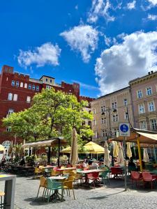 布达佩斯Cedar Inn Budapest - Palace District的一组桌椅,配有遮阳伞和建筑