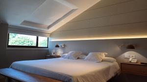 拉瓦克拉圣雅各之路酒店的卧室配有一张大白色床和窗户